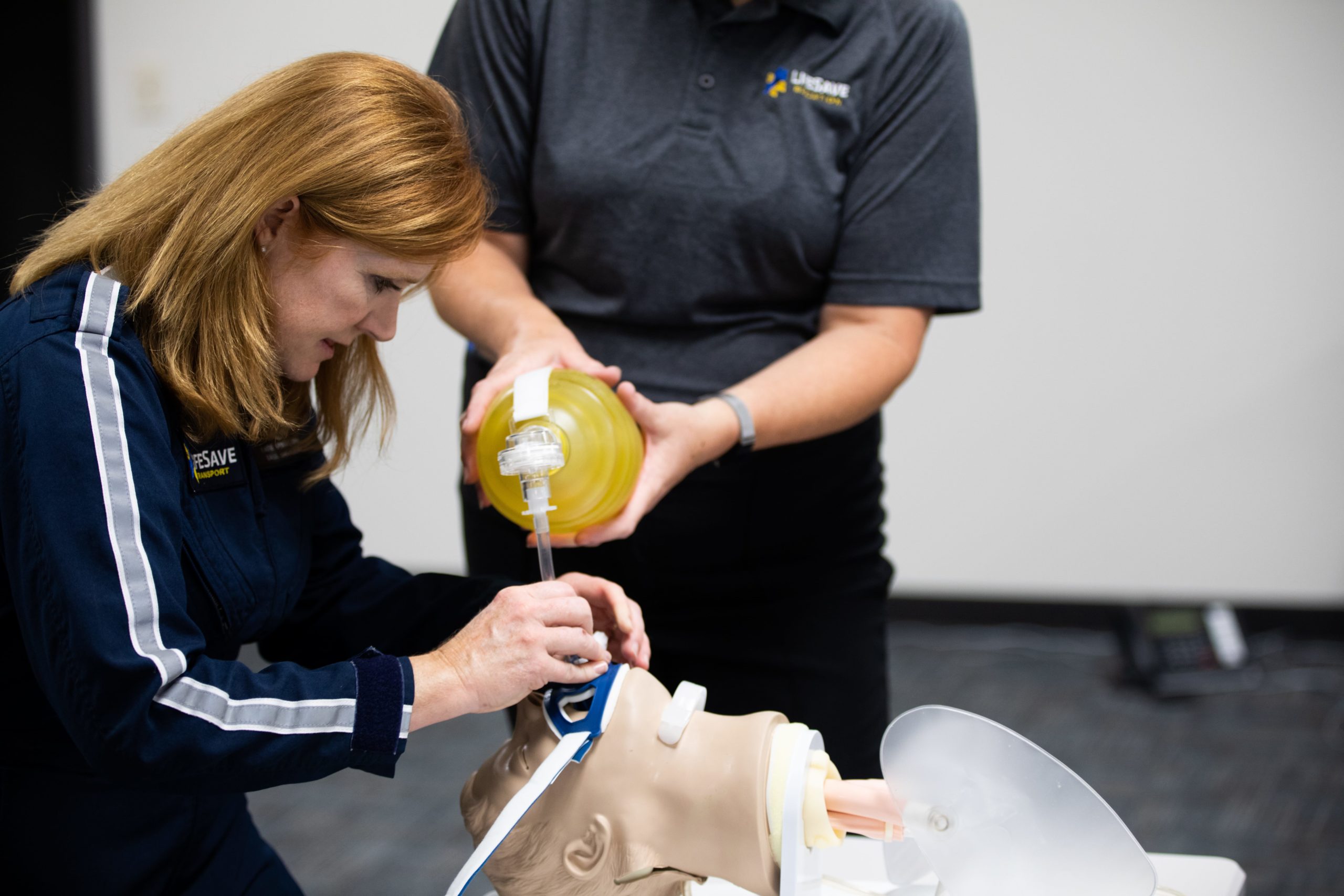 Paramedic practicing CPR on dummy.